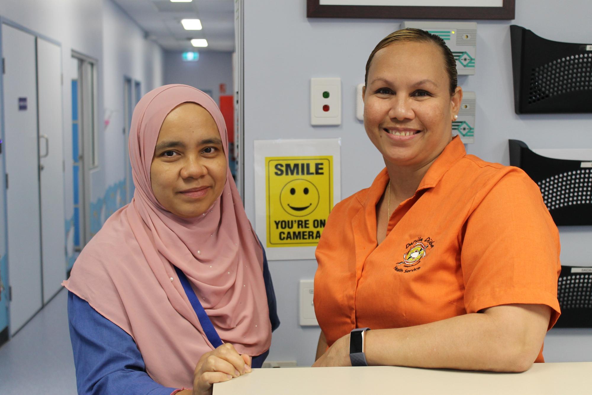 Two Danila Dilba Rapid Creek clinic staff members smile for a photo inside the clinic.